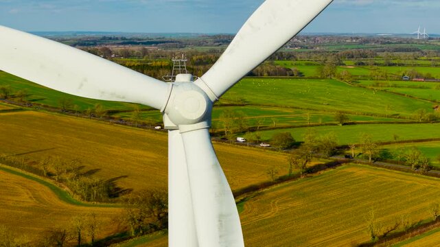 Wind farm generating green energy. Wind turbine rotating strong rotor blades to generate green electricity. Rotating heavy blades generating environmentally friendly power on wind farm