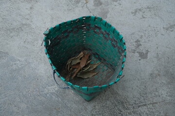 photo of a green trash can on the ground