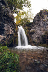 Obraz premium watewaterfall in autumn with green leaves