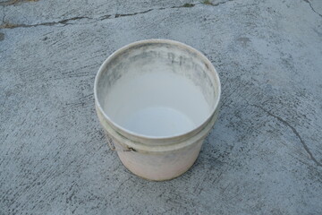 Photo of an empty white bucket on the ground