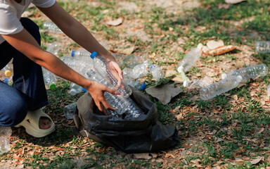 A group of environmental conservation volunteers is helping each other collect trash in a public park.