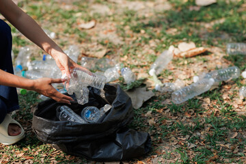 A group of environmental conservation volunteers is helping each other collect trash in a public park.