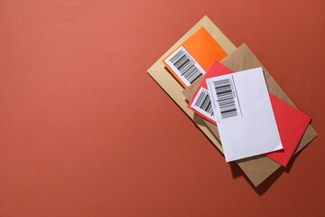 Post office. Different paper envelopes on red-brown background, top view. Space for text