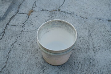 Photo of an empty white bucket on the ground