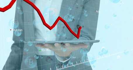 Image of red line and statistics processing over bitcoin symbols and businessman with tablet
