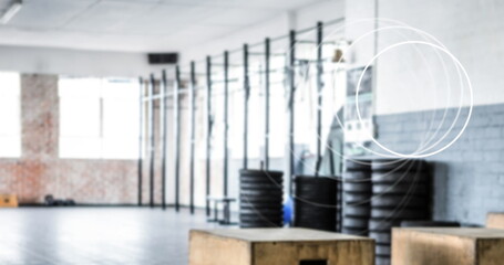 Image of white circles spinning over industrial gym interiors