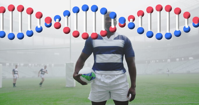 Image of dna strand over male rugby players at stadium