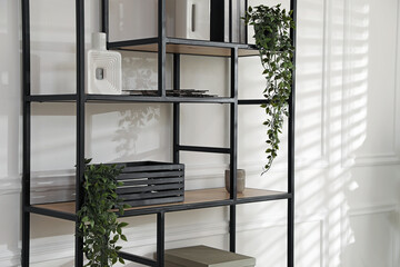 Stylish shelving unit with decor near white wall indoors