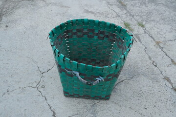 photo of a green trash can on the ground