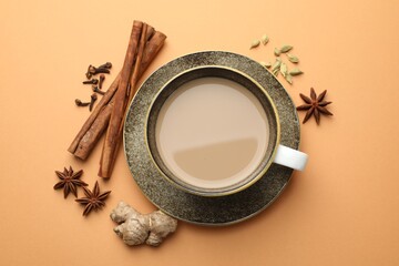 Aromatic Masala tea in cup and spices on beige background, flat lay