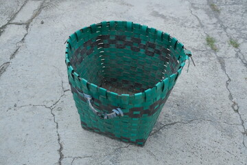 photo of a green trash can on the ground