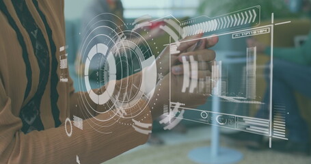 Digital interface with data processing against mid section of woman using hand sanitizer at office