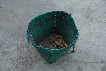 photo of a green trash can on the ground