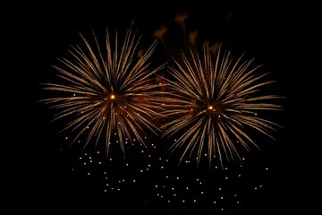 Golden fireworks in the dark sky with festive bokeh. New year celebration concept
