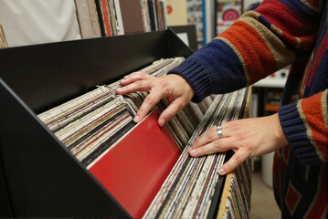 Person Browsing Vinyl Record Collection in Cozy Shop