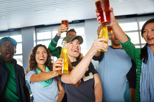 Pub, sports and friends cheers with beer watching soccer match with happiness for winning goal. Supporters, alcohol and fans streaming broadcast television of football game for league in bar.