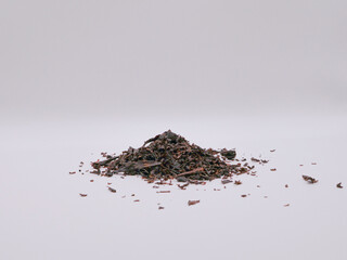 A pile of dry black tea leaves, on a white white  front view