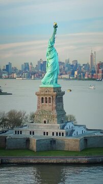 Aerial view of the Statue of Liberty at dusk. Manhattan and New Jersey skyline. New York City, United States. Shot from a helicopter.