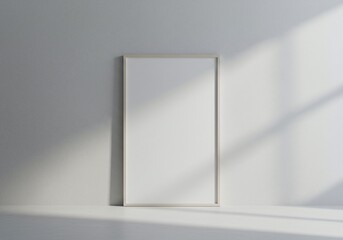 Empty portrait picture frame leaning against a wall with sunlight casting shadows. The frame is ready for your artwork or text
