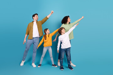 Naklejka premium Happy family posing together in casual clothing against a vibrant blue background celebrating joy and unity