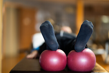 A close up shot of a patients legs resting on rehabilitation balls, aiding in recovery and...