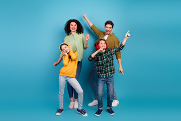 Happy family dancing together in colorful casual outfits on vibrant blue background celebrating joy and togetherness