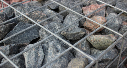 Top Part of Gabion Wall with Huge Gravel Stones Inside Stone Fence. Landscaping and Outdoor Design Stock Photo 
