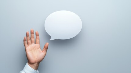 Hand holding speech bubble, communication concept on gray background