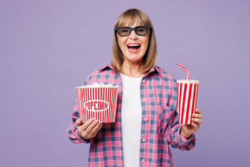 Elderly blonde woman 50s year old wear violet shirt casual clothes 3d glasses watch movie film hold...