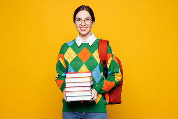 Young smiling smart girl student she wear green casual clothes backpack bag hold stack of books...