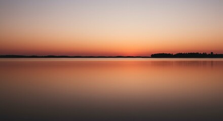 Naklejka premium Serene Sunset Over Calm Lake Water with Distant Trees Silhouette