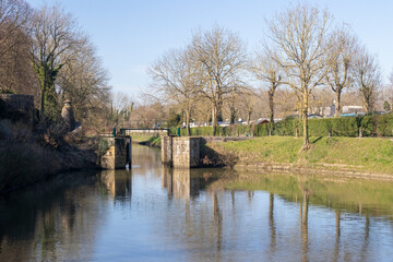 Obraz premium Reflections of the ramparts and trees in Bergues, northern France