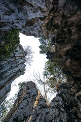 Awe-Inspiring Limestone Cliff: A dramatic perspective, looking up towards the sky through a towering limestone cliff, showcasing geological formations.