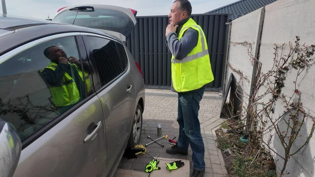 A guy changes tire on street to summer tire in nature