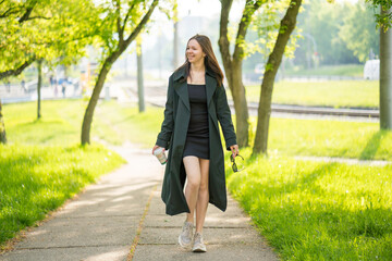 Woman walking in park with coffee