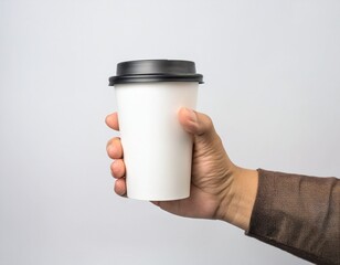 Mockup de una mano masculina sosteniendo un vaso de café de papel sobre un fondo gris claro. – Imagen de alta calidad