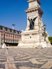 Lisbon, Portugal:. Restauradores Square. Monumento aos Restauradores Monument detail, Palacio Foz palace and Portuguese pavement.