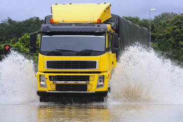 Heavy vehicles wade through the floodwaters