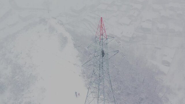  Master works on a high-voltage line in a heavy snowstorm.