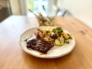 Homemade beef with tomato paste and salad on wooden table