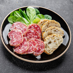 Dry-cured sausage salami appetizer dish fresh gourmet food background on the table rustic food top...