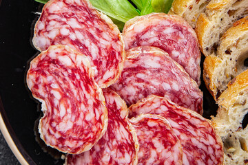 Dry-cured sausage salami appetizer dish fresh gourmet food background on the table rustic food top view copy space