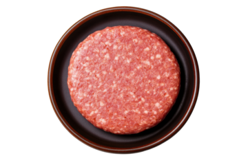 Raw ground beef patty on dark plate against black background, cut out