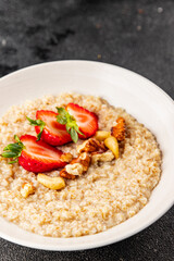 Oatmeal porridge strawberries nuts healthy breakfast appetizer dish fresh gourmet food background on the table rustic food top view copy space keto and paleo diet vegetarian and vegan food