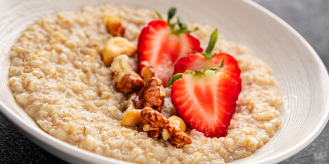 Oatmeal porridge strawberries nuts healthy breakfast appetizer dish fresh gourmet food background on the table rustic food top view copy space keto and paleo diet vegetarian and vegan food