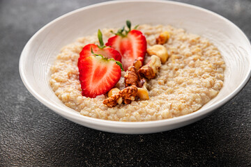 Oatmeal porridge strawberries nuts healthy breakfast appetizer dish fresh gourmet food background on the table rustic food top view copy space keto and paleo diet vegetarian and vegan food