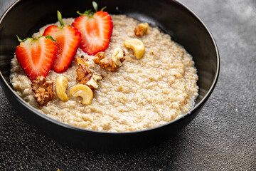Oatmeal porridge strawberries nuts healthy breakfast appetizer dish fresh gourmet food background on the table rustic food top view copy space keto and paleo diet vegetarian and vegan food