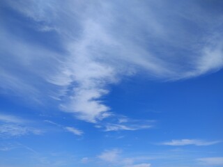 Fototapeta premium Dramatic Wispy Clouds Against Vibrant Blue Sky Creating Natural Abstract Pattern in Daytime