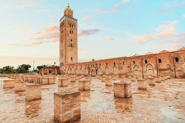 Fototapeta premium The majestic Koutoubia Mosque and its iconic minaret tower stand tall against the backdrop of a vibrant sunset in Marrakech, Morocco