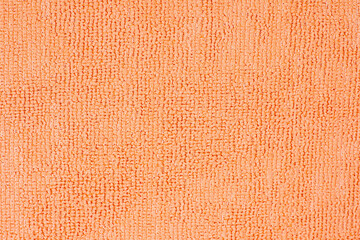 Fototapeta premium Microfiber cleaning cloth surface texture close up showing the looped pile of the fabric in vivid orange color, ideal for backgrounds and textures